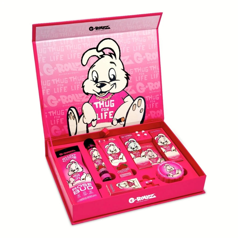 -ROLLZ Gift Box Thug for Life S, geöffnete pinke Geschenkbox mit Banksy-Graffiti-Hasen-Motiv und arrangiertem Set-Inhalt aus Cones, Papers, Tips, Box und Grinder